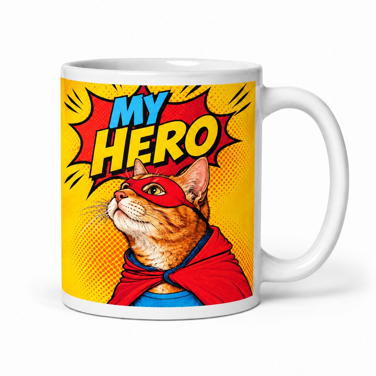 A white mug with a pop art portrait of a cat in a red superhero mask and cape under the words 'My Hero'